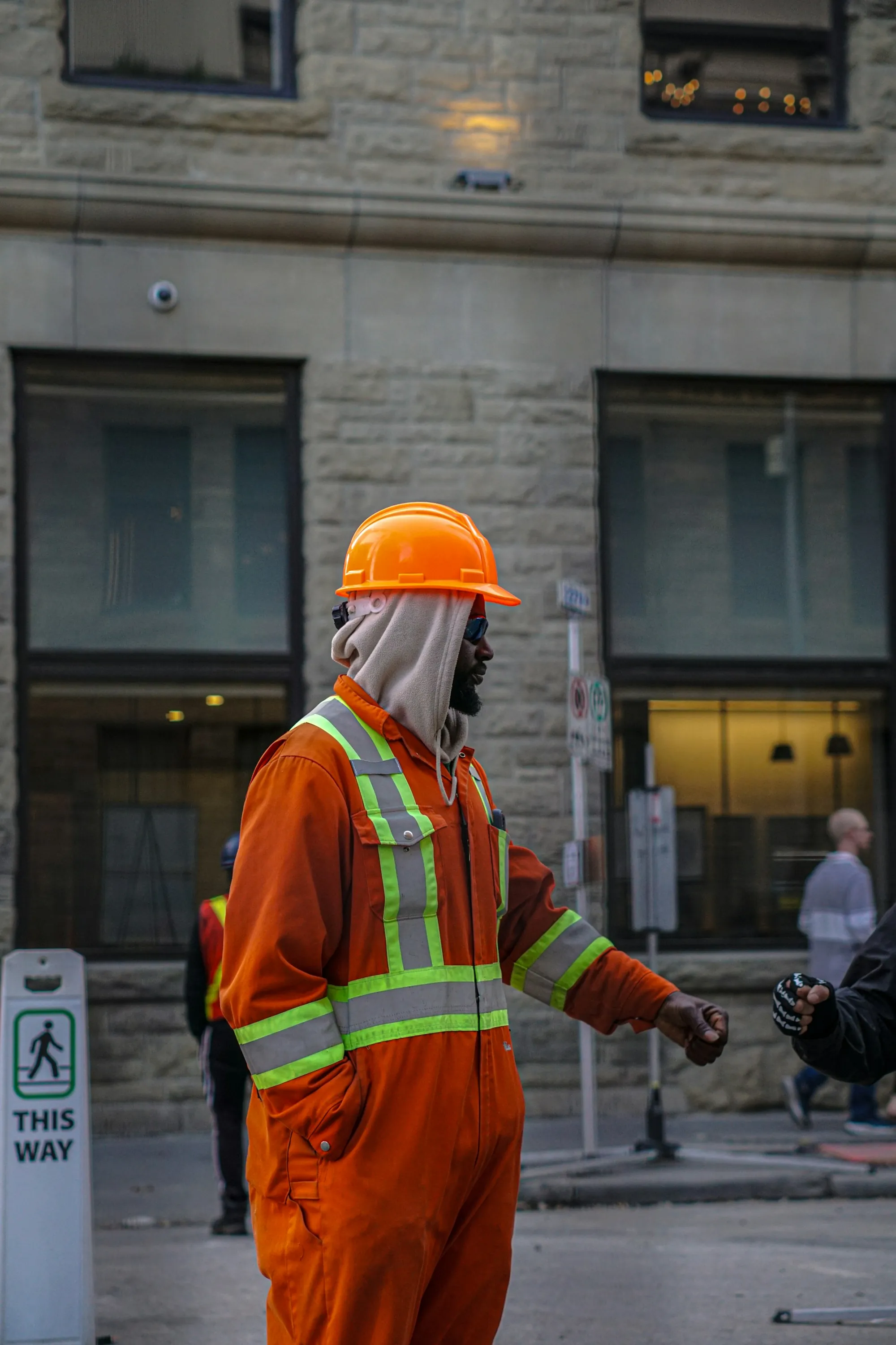 Worker in a hard hat, respirator and hi-vis jacket