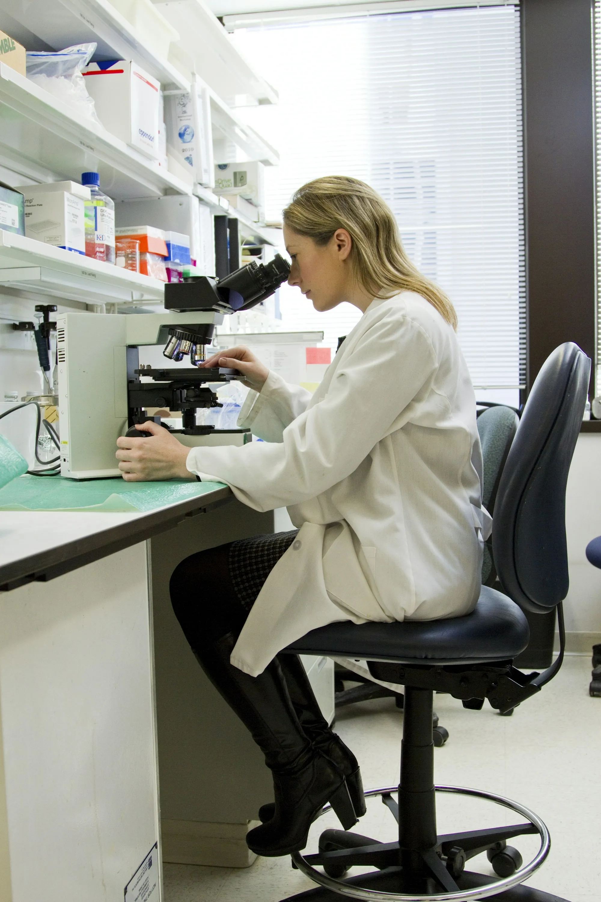 Lab technician working at a microscope
